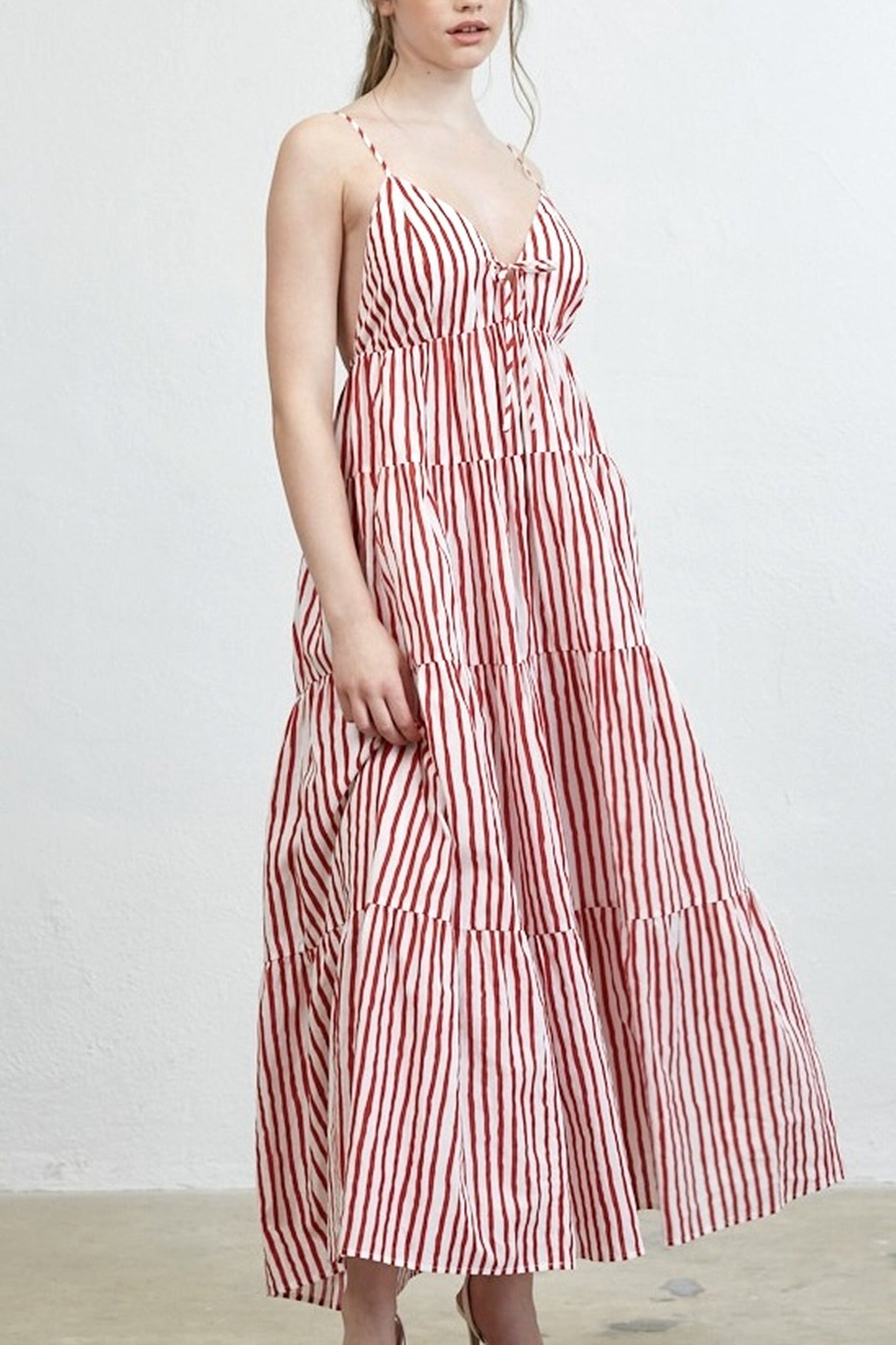 Woman wearing a red and white striped dress against a plain background