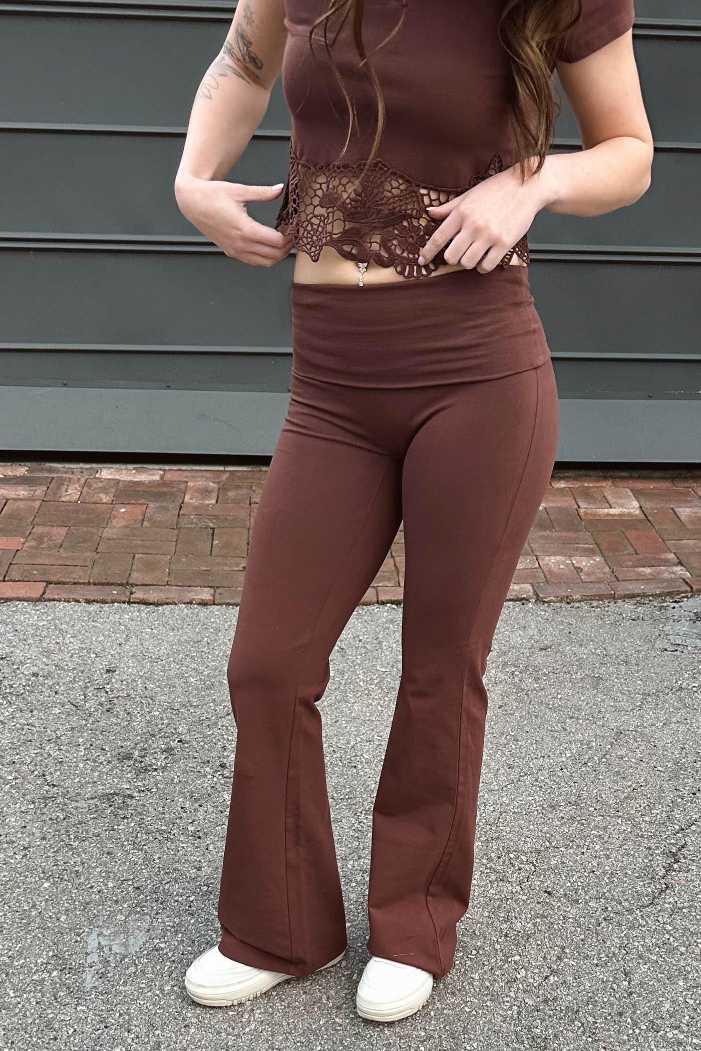 Person wearing a brown outfit with lace detailing in an outdoor setting