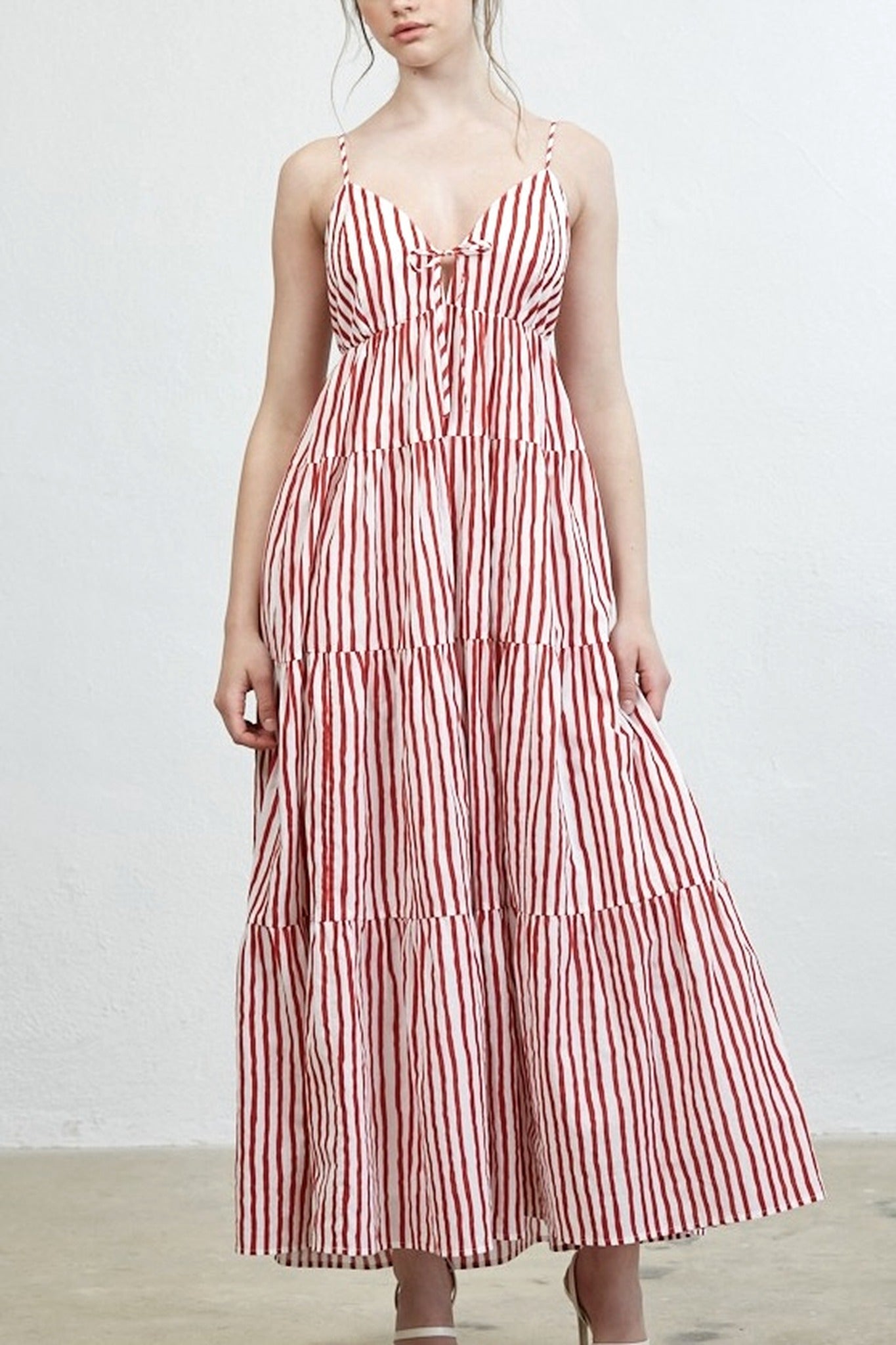 Woman wearing a red and white striped dress against a plain background
