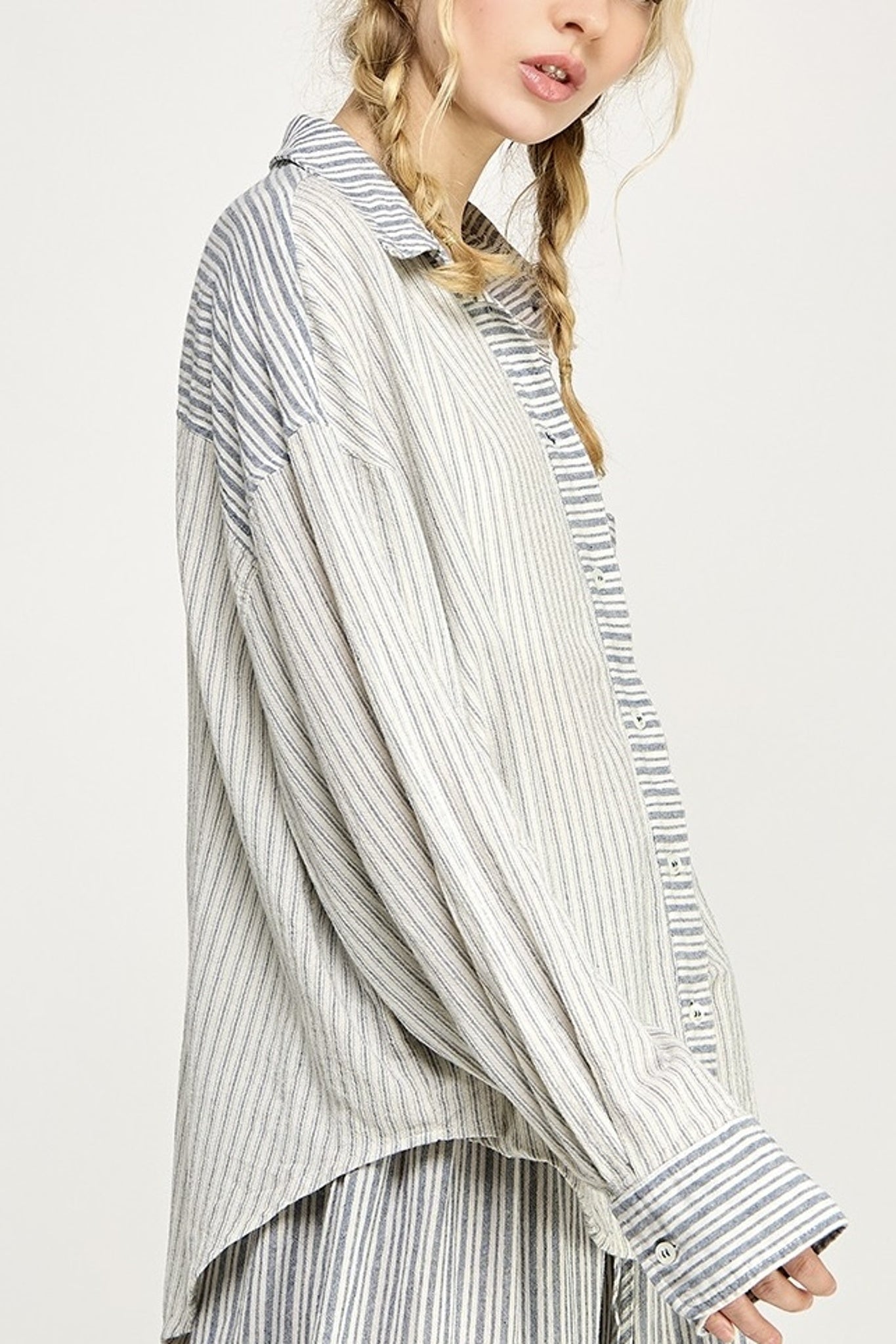 Person wearing a long, striped shirt with a white background