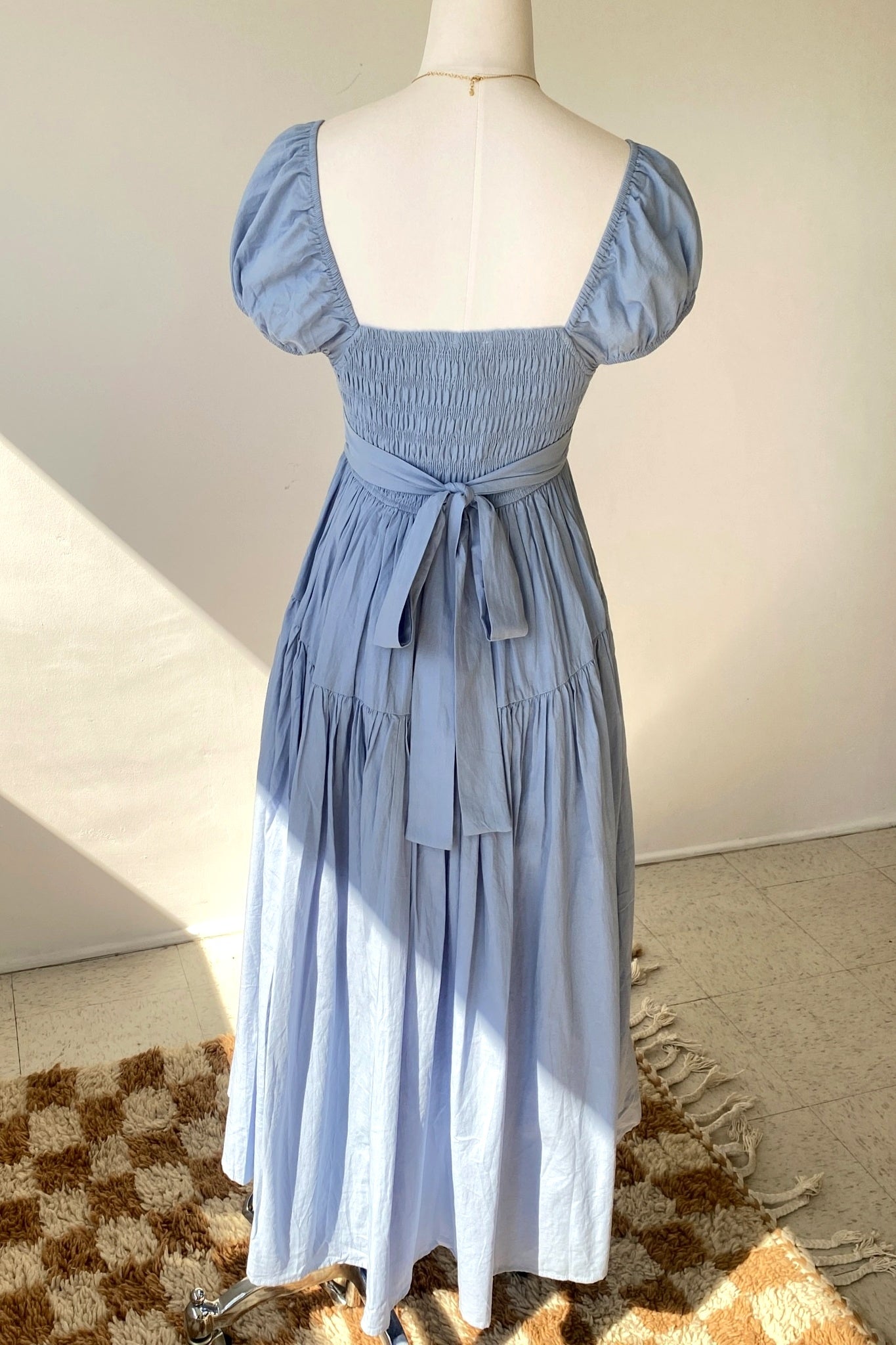 Blue dress on a mannequin against a neutral background