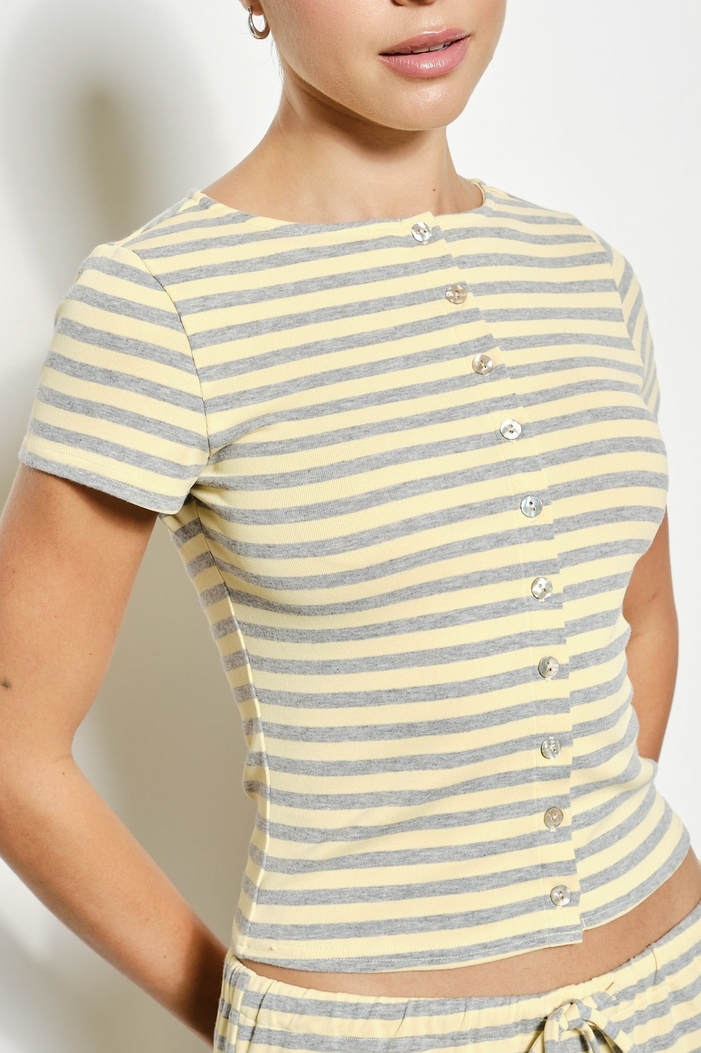 Yellow and gray striped shirt worn by a person on a plain background