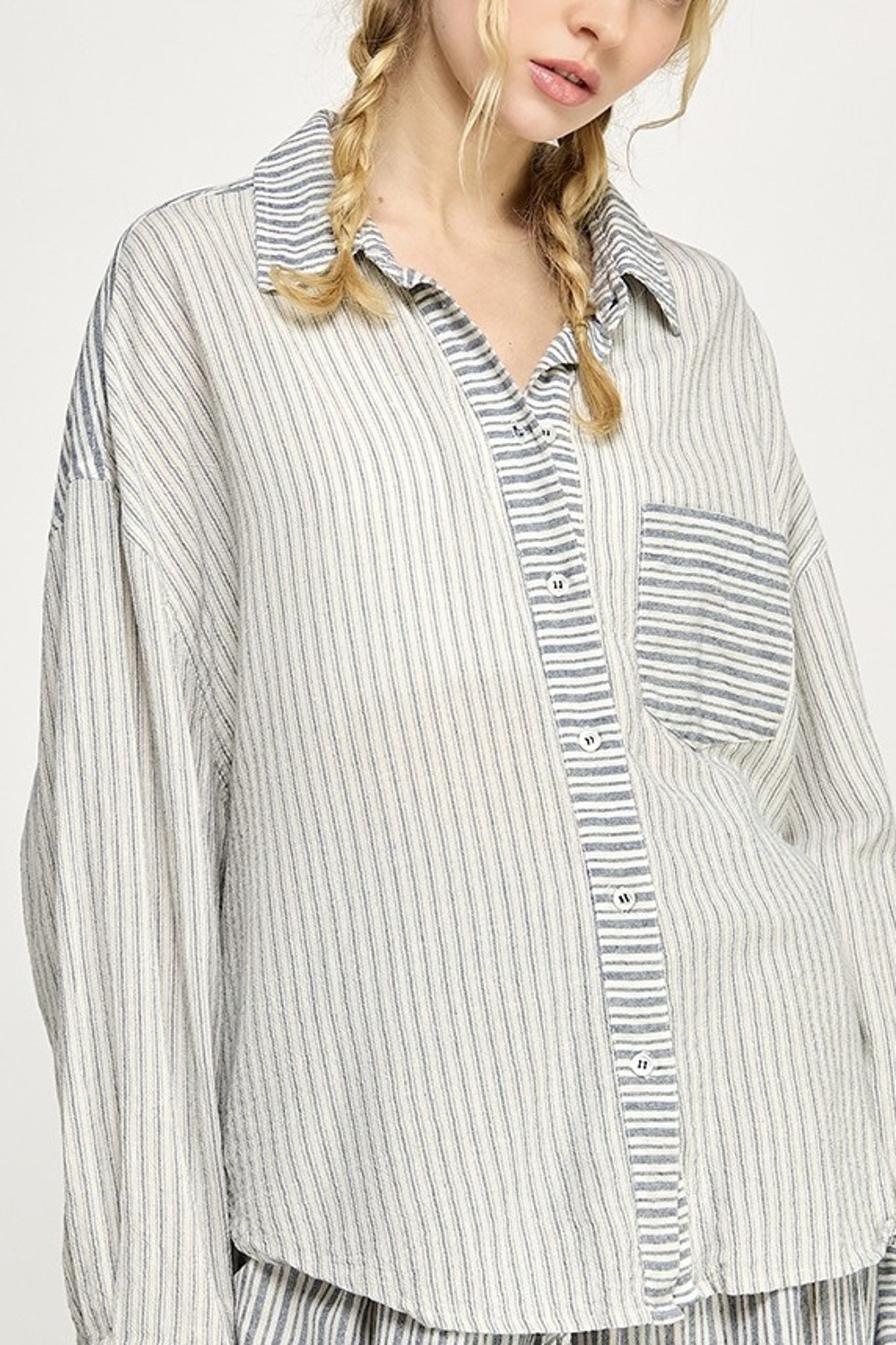 Person wearing a striped shirt with a white background