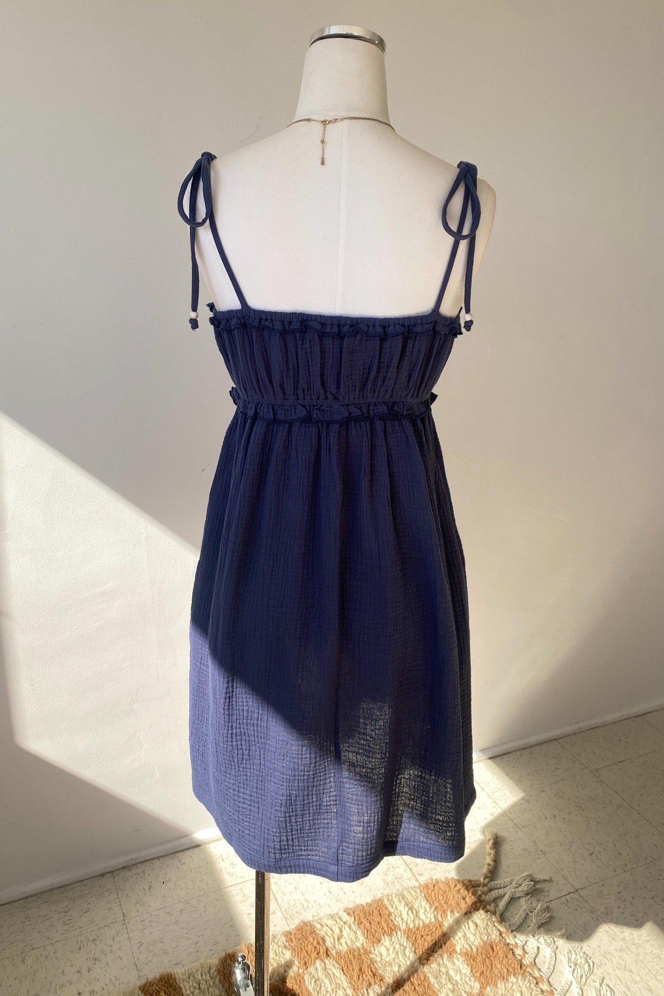 Navy blue dress on a mannequin against a plain background