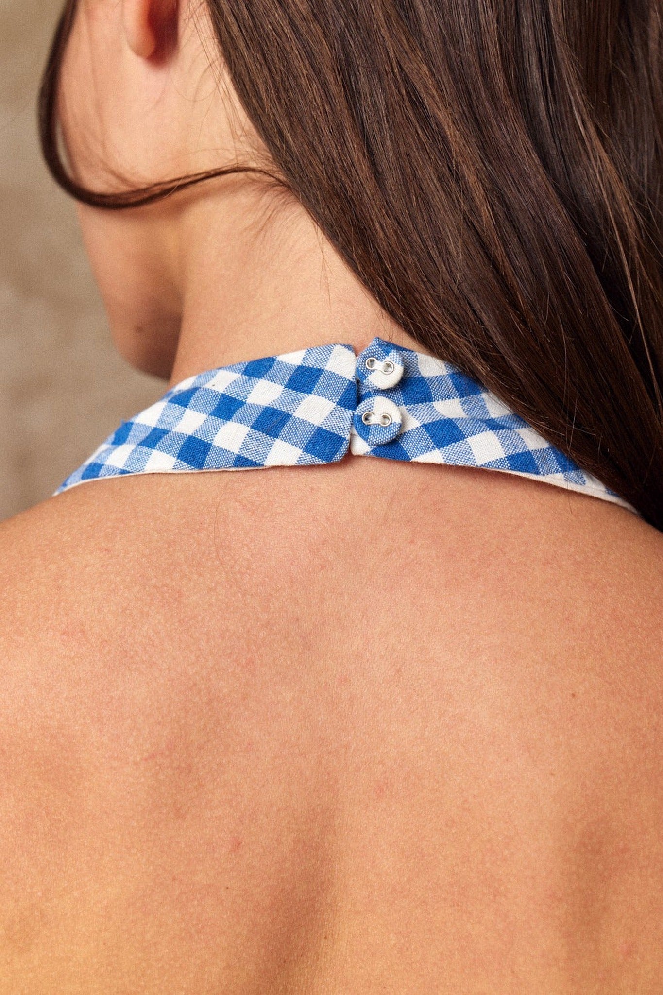 Blue and white checkered top with buttons on a person's shoulder