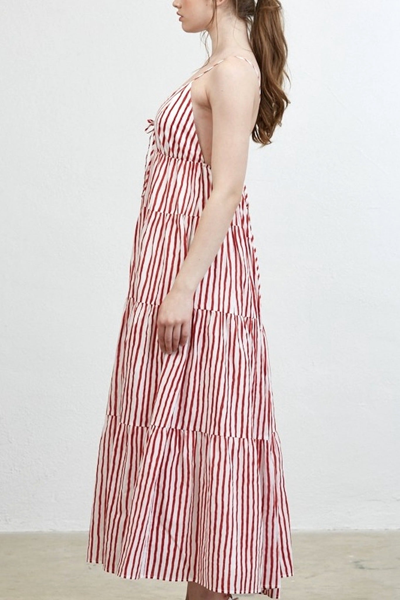 Woman wearing a red and white striped dress against a plain background